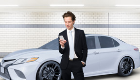 A man in a suit standing next to a white car