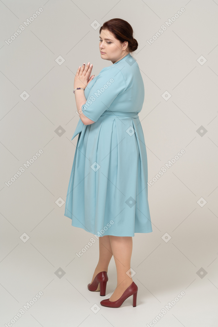 Sad woman in blue dress posing in profile