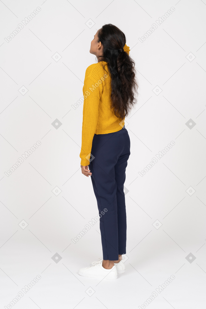 Side view of a girl in casual clothes standing with hand on head