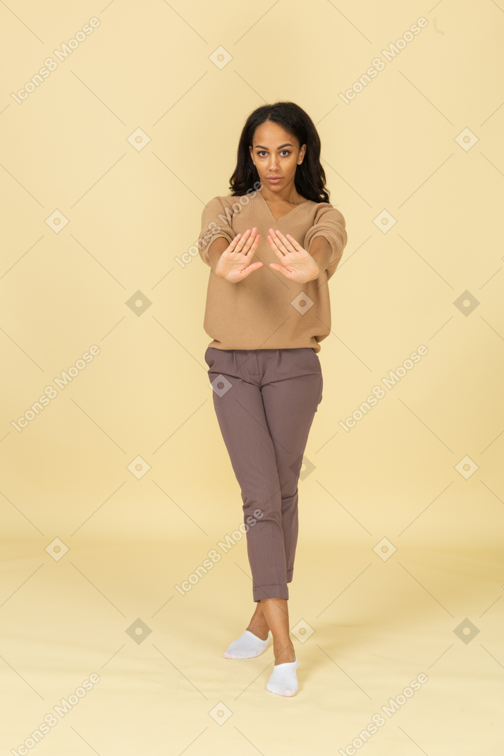 Vista frontal de uma jovem mulher de pele escura estendendo as mãos