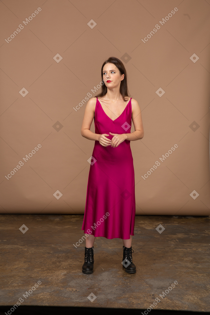 Vista frontale di una bellissima giovane donna in abito rosso che guarda in alto