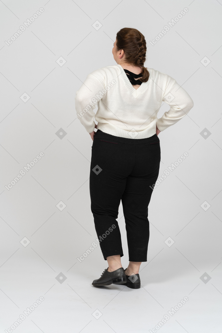 Женщина больших размеров в повседневной одежде, положив руки на бедра
