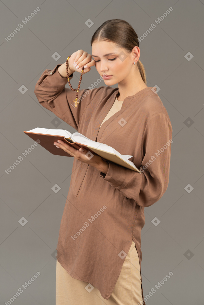 책을 읽는 동안 눈을 비비는 젊은 여자
