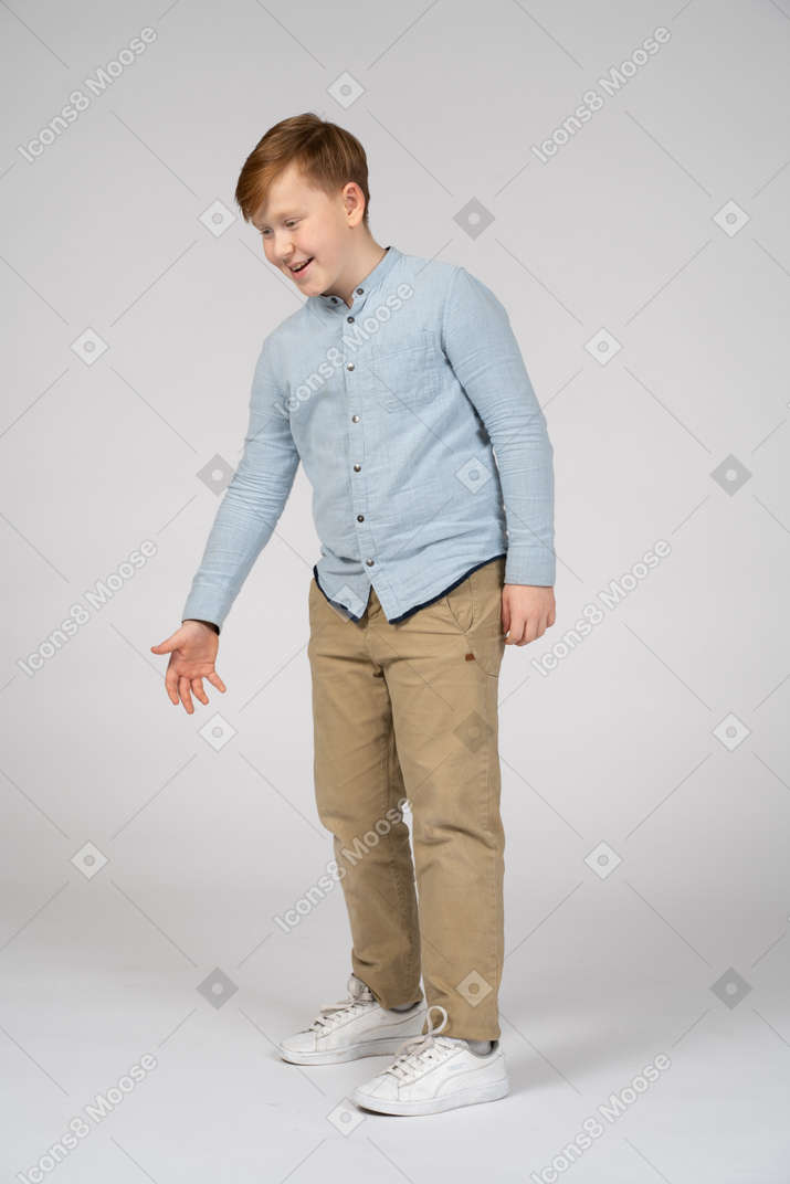 Cute boy bending with extended arm and looking down