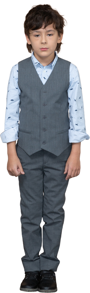 Front view of a sad boy in suit looking at camera