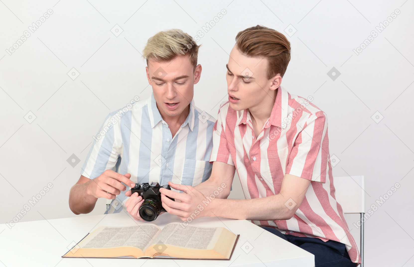 Coppia gay seduti al tavolo e calcolando le impostazioni della fotocamera