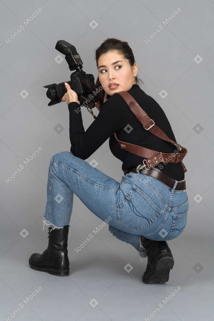 Young woman turning around while staying on knees with camera