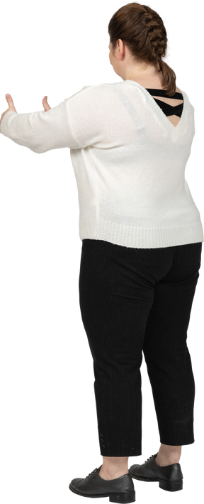 Happy woman in white sweater showing thumbs up