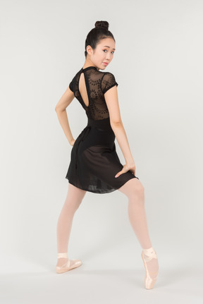 Young asian ballerina standing half sideways in position to camera