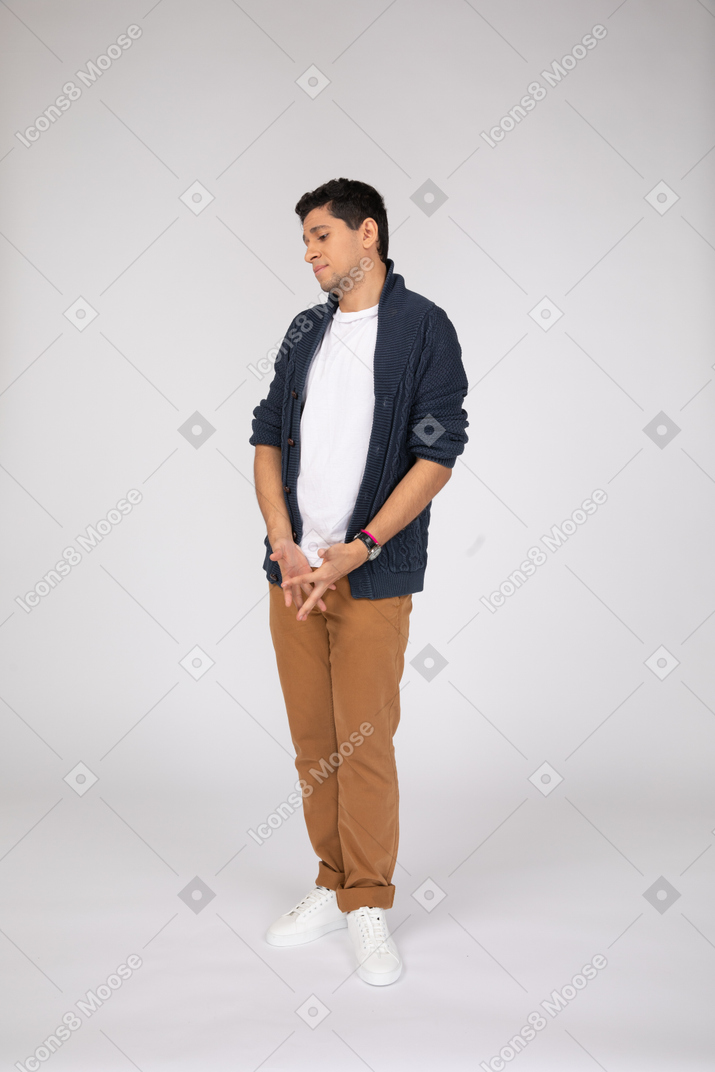 Shy young man standing and looking down