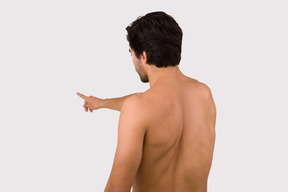 Man standing back to the camera and pointing at something