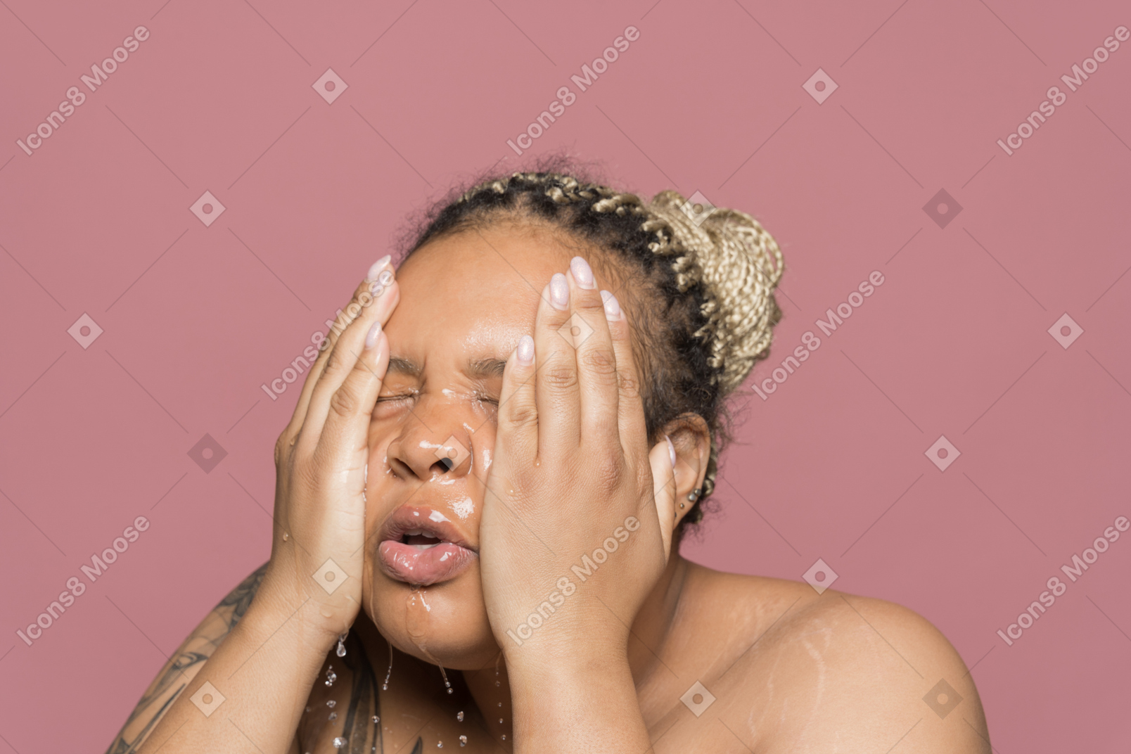 Refreshed african-american woman washing her face with both hands