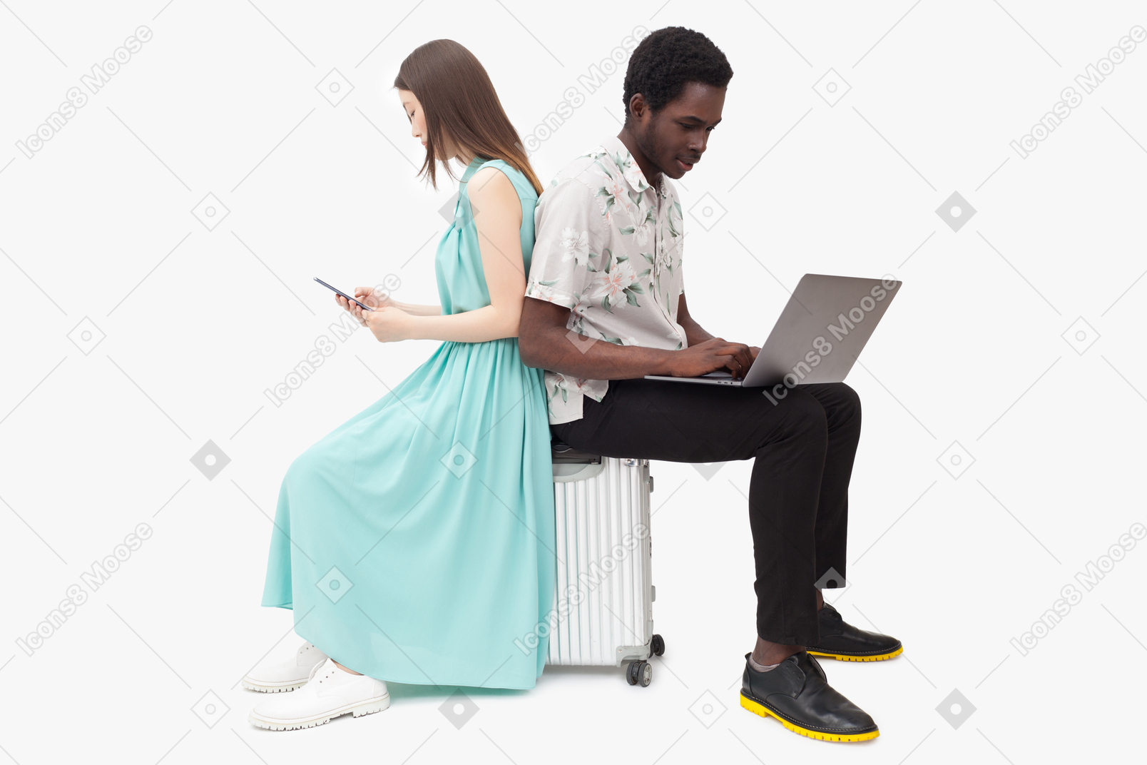 Interracial couple sitting on suitcase and and using gadjets