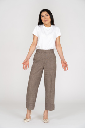 Front view of a young lady in breeches and t-shirt outspreading her hands