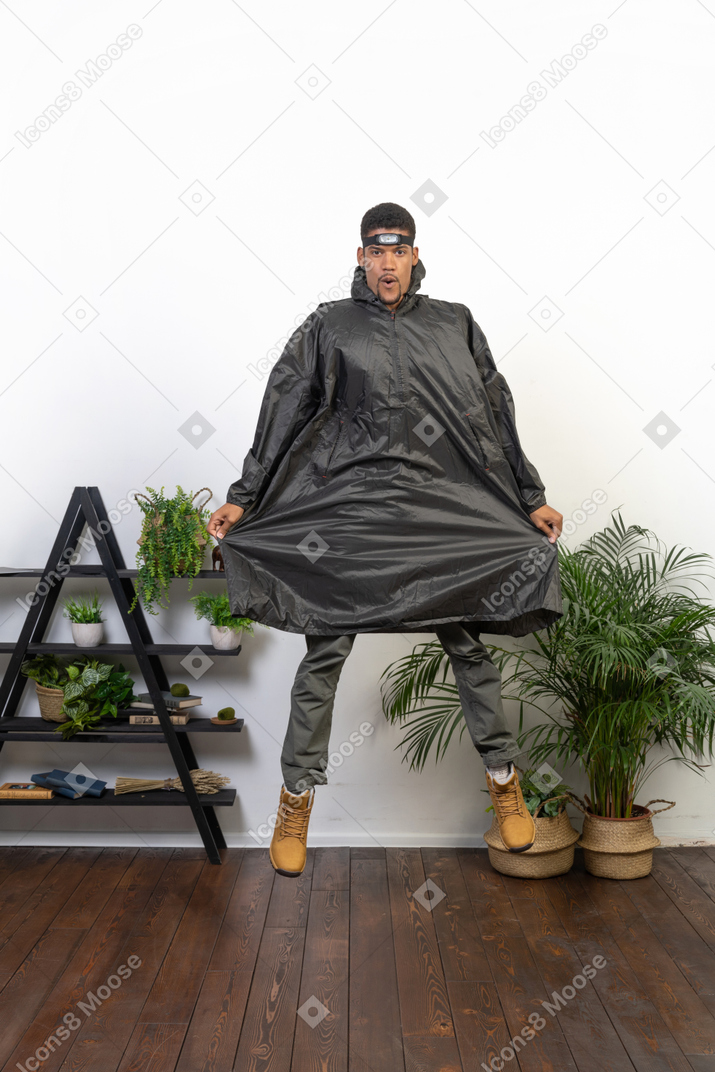 Man in raincoat jumping up