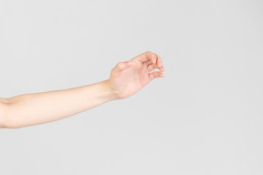 Mirada lateral de la mano femenina parcialmente apretada en el puño