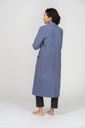 Vista posteriore di una donna in cappotto con le braccia incrociate