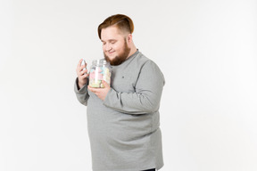 Big bearded man holding jar of marshmallows