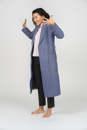 Donna felice in cappotto blu che gesturing
