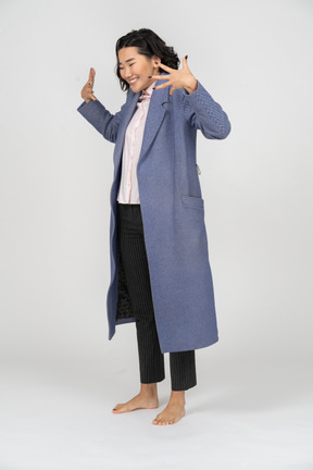 Femme heureuse en manteau bleu gesticulant