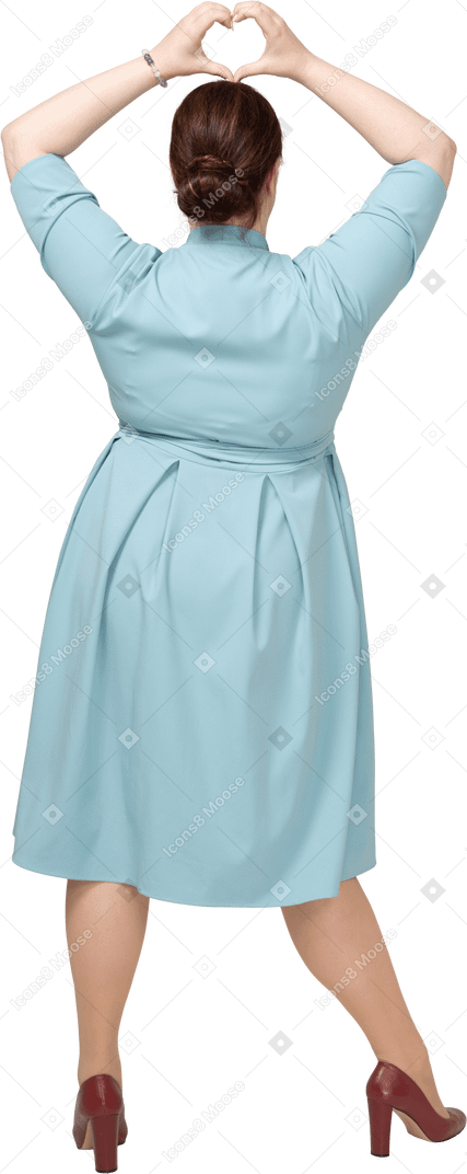 Вид сзади женщины в синем платье, показывающей жест сердца