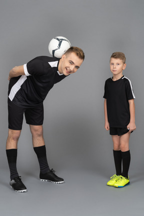 Full-length of a young man coaching little boy