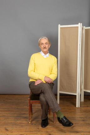 Man sitting cross-legged and looking at camera