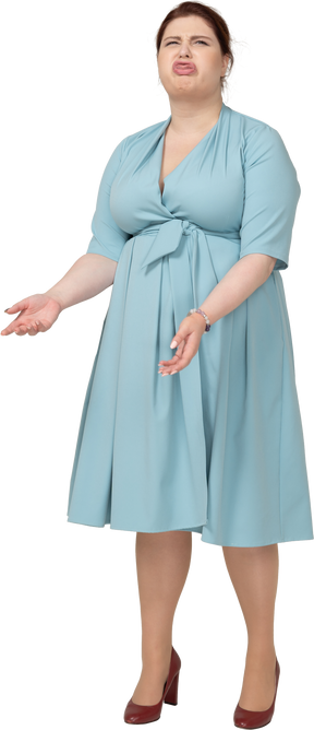 Вид спереди женщины в синем платье корчит рожи