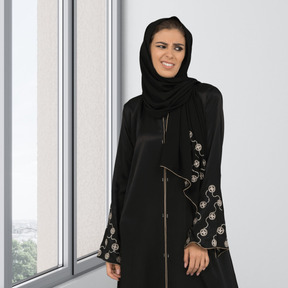 A wincing muslim woman in black hijab