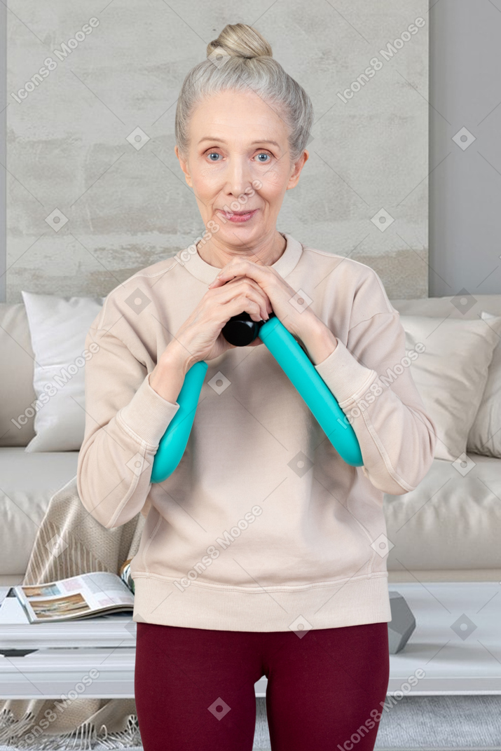Пожилая женщина тренируется дома
