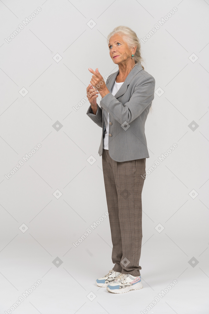 Vista lateral de uma senhora de terno apontando com o dedo