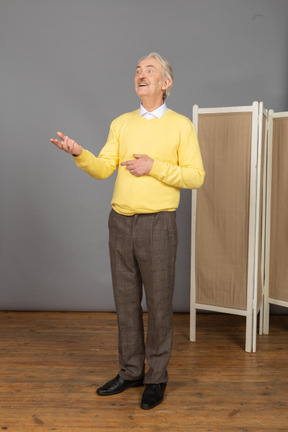 Three-quarter view of an inspired old man raising his hand
