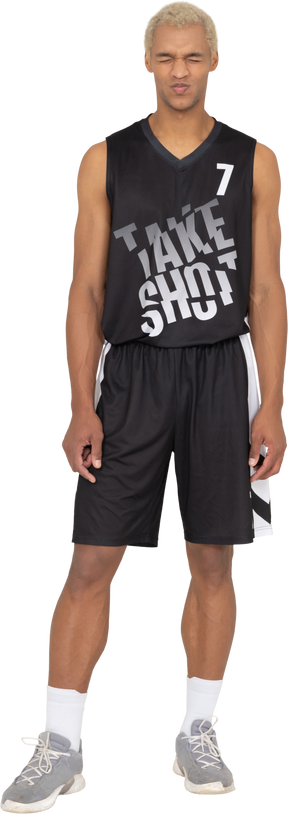 一个不高兴的年轻男篮球运动员闭上眼睛的前视图