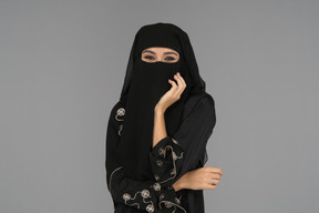 A covered muslim woman looking at camera