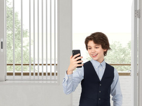 A boy in a suit taking a picture with a cell phone