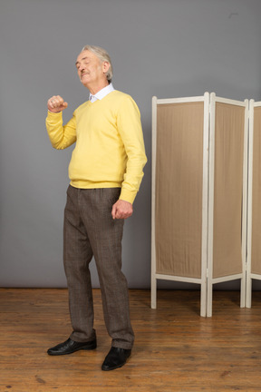 Three-quarter view of an old man raising hand and clenching fist