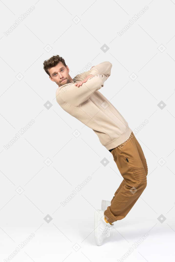 Young guy doing a toe stance with his hands folded