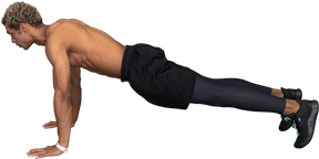 Vista lateral de um homem afro sem camisa fazendo flexões