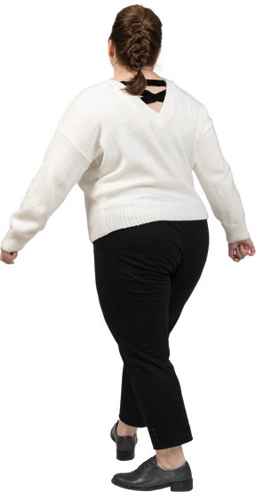 Vista posteriore di una donna grassoccia in abiti casual che cammina