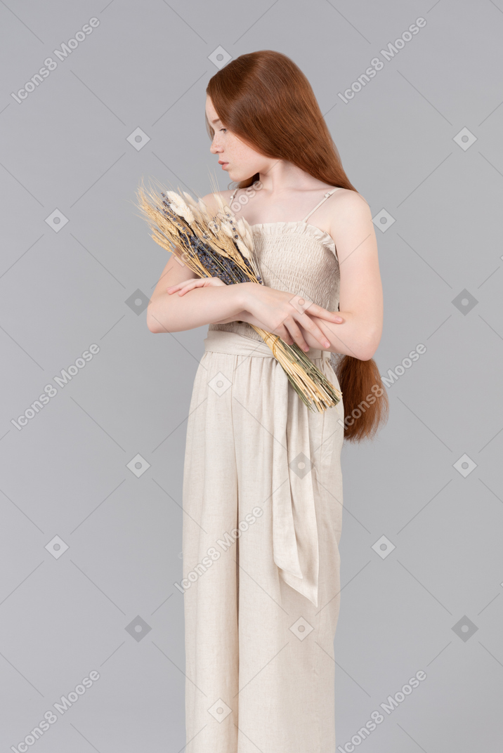 Teenage girl holding bouquet of dried flowers