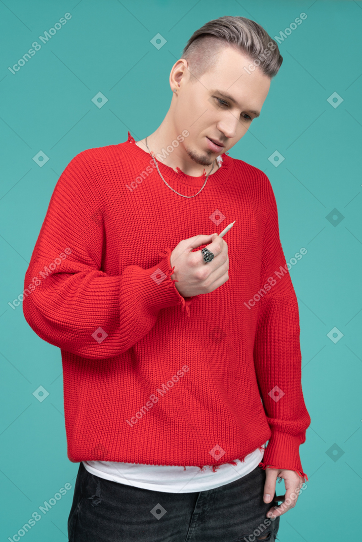 Nachdenklicher junger mann, der eine zigarette hält