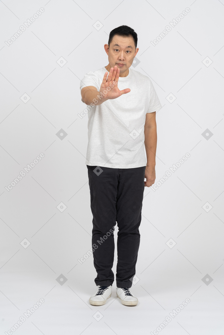 Front view of a man in casual clothes making stop gesture