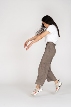 Side view of a young lady in breeches and t-shirt outstretching hands