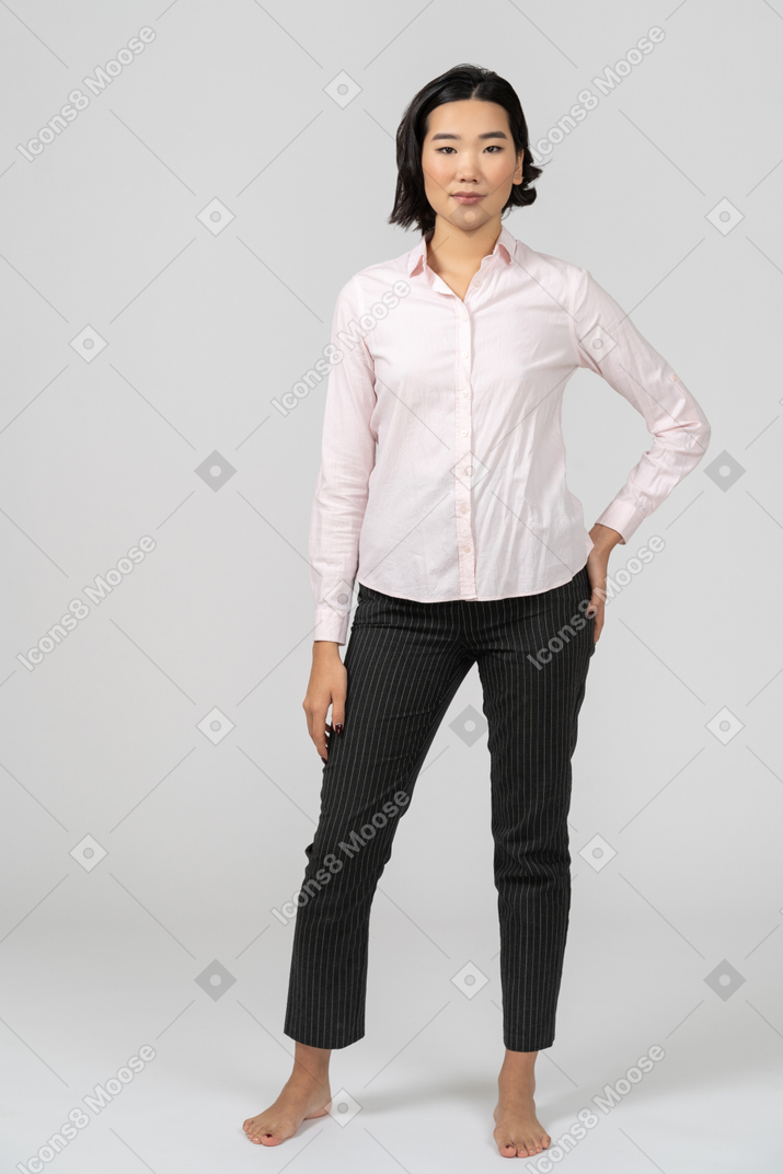 Mulher em roupas de escritório com a mão no quadril