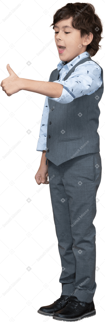 Side view of a cute boy in grey suit showing thumb up