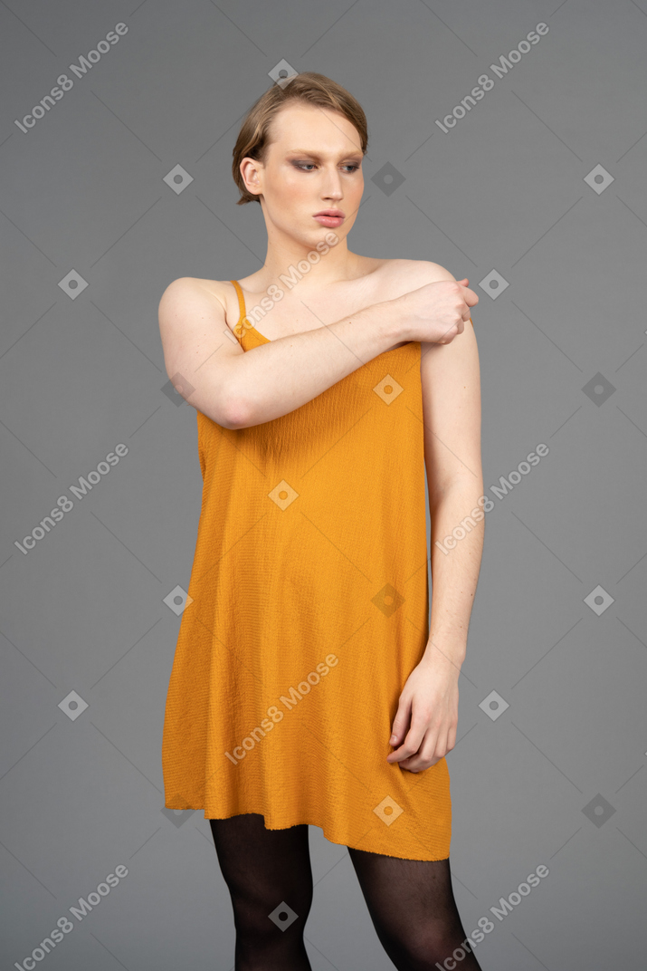 Young transgender person sliding dress strap off shoulder