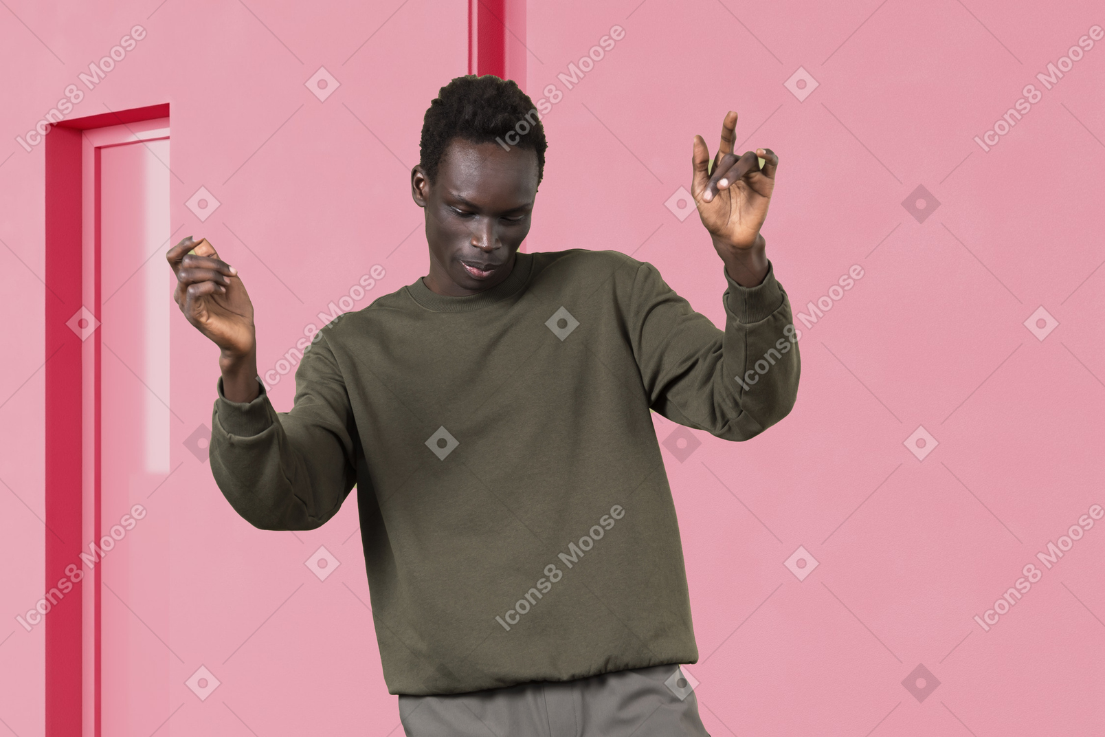 A man dancing in front of a pink wall