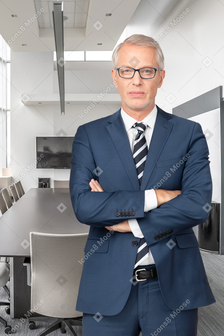 A man in a suit and tie standing in an office