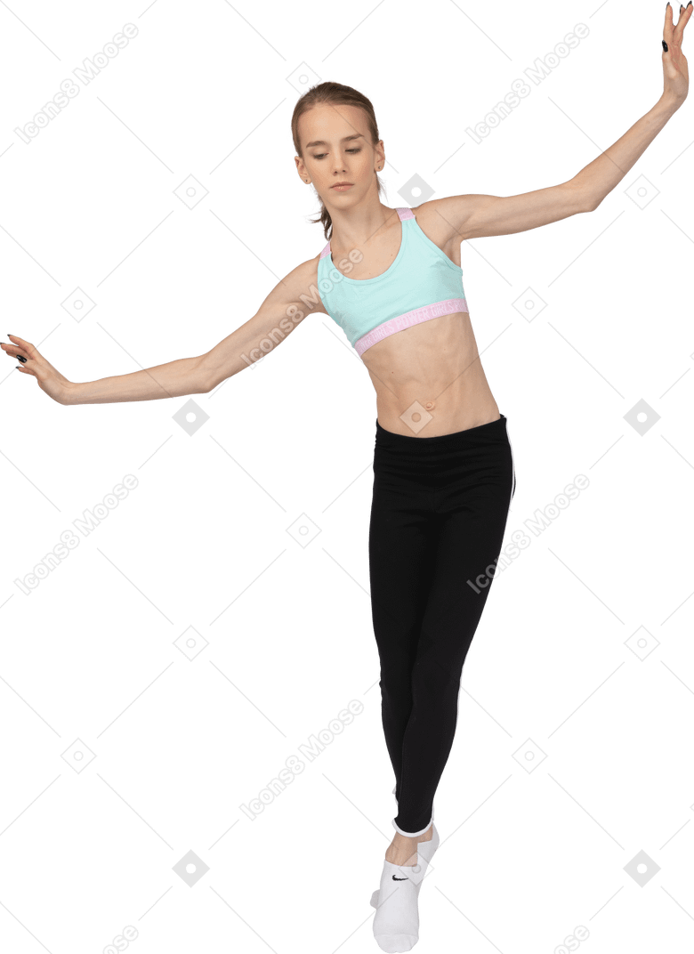 Front view of a teen girl in sportswear balancing on her tiptoes