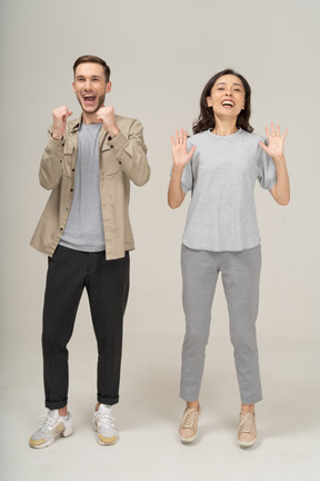 Joyful young couple cheering